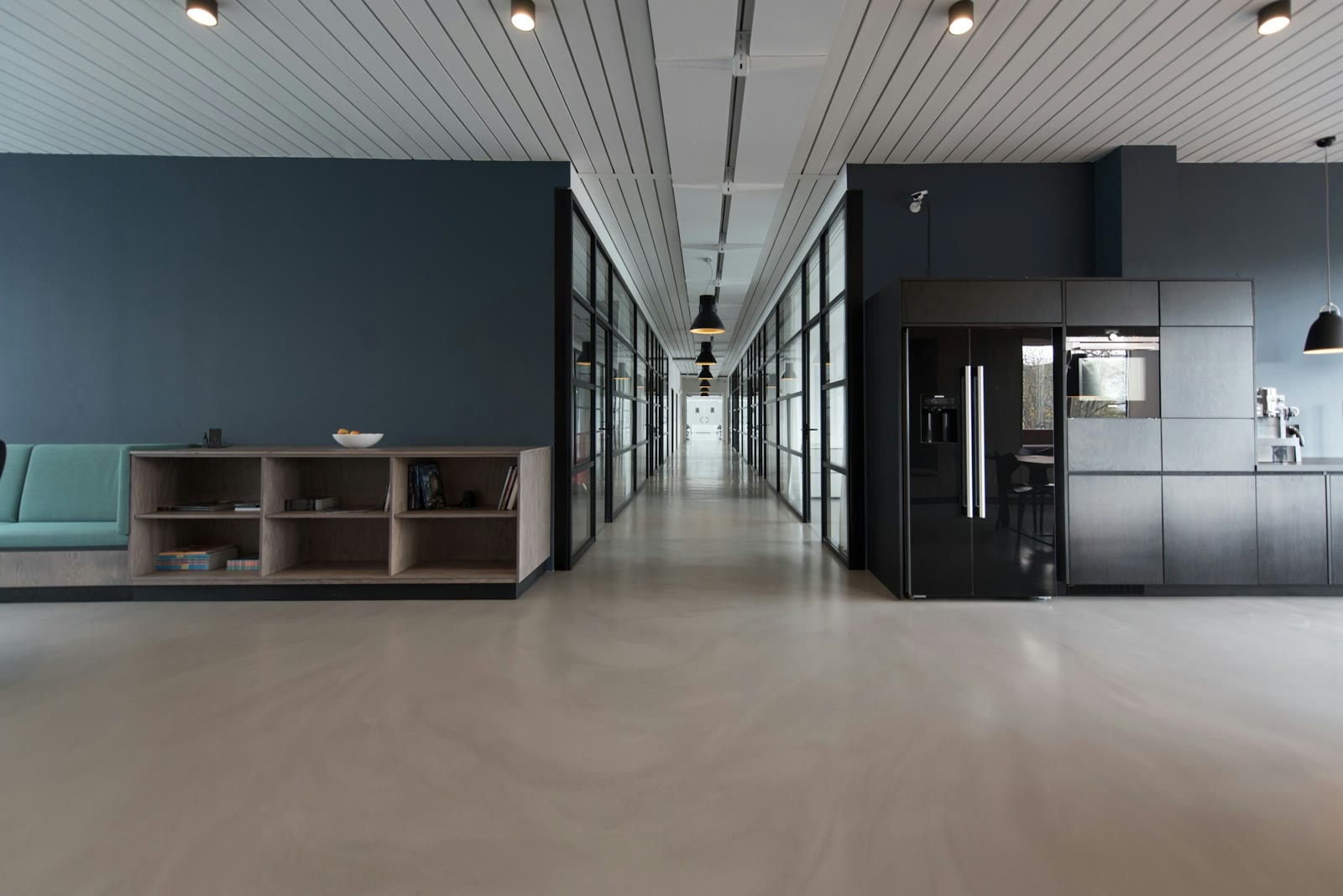 Sunlit open office with long wooden tables and large windows